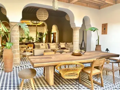 a living room with a wooden table and chairs at Riad Le Pèlerin in Marrakech