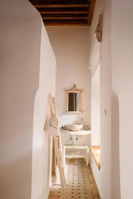a white bathroom with a sink and a toilet at Riad Le Pèlerin in Marrakech