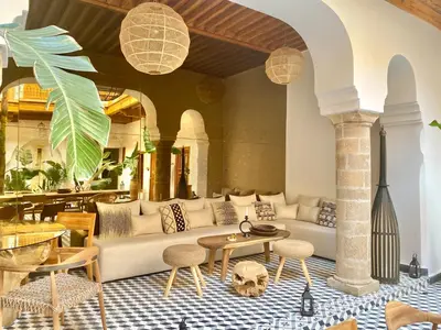 a living room with a couch and tables and chairs at Riad Le Pèlerin in Marrakech