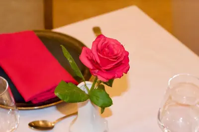 a pink rose in a white vase on a table at La Claire Fontaine in Marrakech