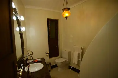 a bathroom with a sink and a toilet and a light at La Claire Fontaine in Marrakech