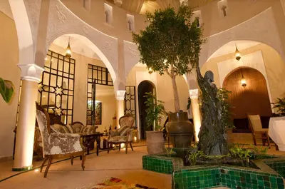 a lobby with a table and chairs and a tree at La Claire Fontaine in Marrakech