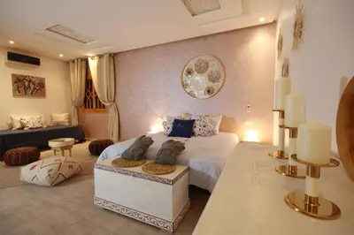 a bedroom with a large bed and a couch at RIAD Miel & Une Nuit in Marrakech