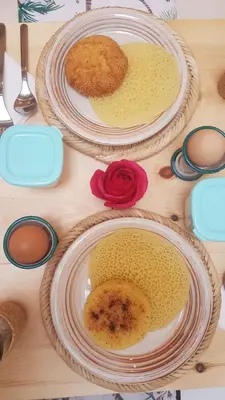 three plates of food on a wooden table at RIAD Miel & Une Nuit in Marrakech