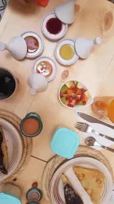 a wooden table with plates of food on it at RIAD Miel & Une Nuit in Marrakech