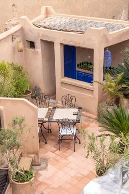 a patio with a table and chairs and a window at Riad Baba Ali & Spa in Marrakech