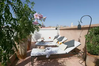 a patio with couches and tables on a balcony at Riad Baba Ali & Spa in Marrakech