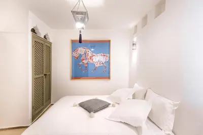 a bedroom with a white bed with white pillows at Riad Hissan in Marrakech