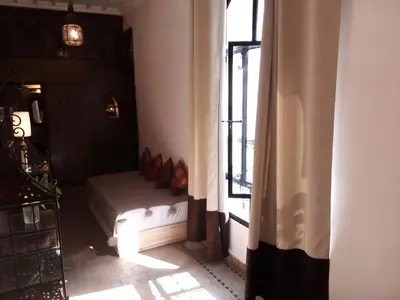 a bedroom with a bed in a room with a window at Riad Mina in Marrakech