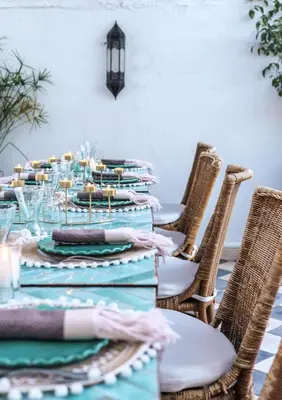 a table with blue and green plates and chairs at Riad Alkemia en exclusivité in Marrakech