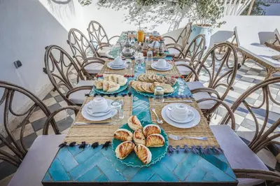 a long table with bread and croissants on it at Riad Alkemia en exclusivité in Marrakech