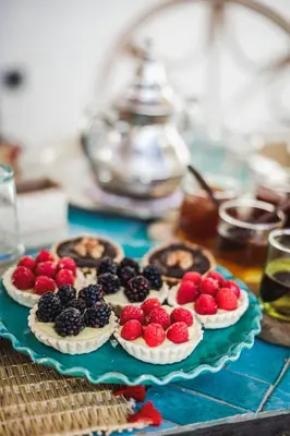 a table topped with four pies with berries on them at Riad Alkemia en exclusivité in Marrakech