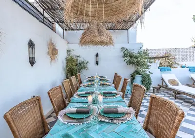 a dining room with a long table and chairs at Riad Alkemia en exclusivité in Marrakech