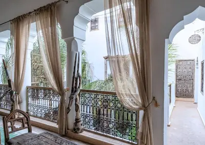 a room with a balcony with windows and a bed at Riad Alkemia en exclusivité in Marrakech
