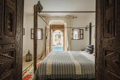 a bedroom with a bed and an open door at Riad Alkemia en exclusivité in Marrakech
