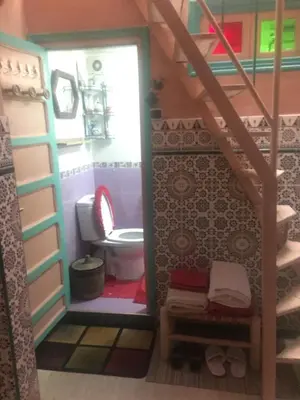 a doll house with a toilet in a bathroom at ALMARKAB Riad in Marrakech