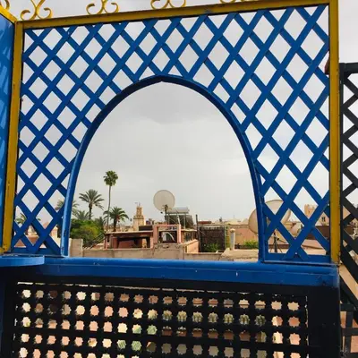 a blue and yellow gate with a view of a city at ALMARKAB Riad in Marrakech