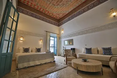 a living room with a bed and a couch at Riad 5 GÉNÉRATIONS in Marrakech