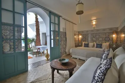 a living room with a couch and a table at Riad 5 GÉNÉRATIONS in Marrakech