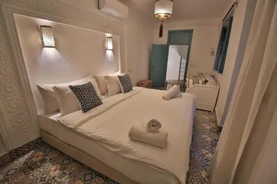 a bedroom with a large white bed with pillows at Riad 5 GÉNÉRATIONS in Marrakech