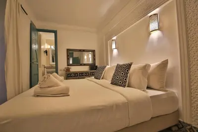 a bedroom with a large white bed with pillows at Riad 5 GÉNÉRATIONS in Marrakech