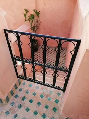 a stairway with a potted plant on a balcony at Riad Aventurine in Marrakech