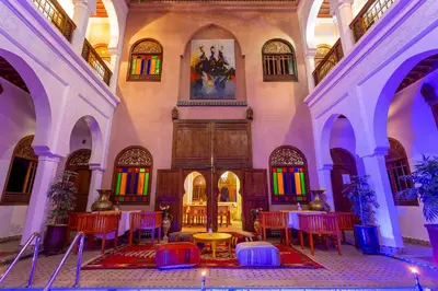 a room with tables and chairs and a painting on the wall at Riad Agdal Royal & Spa in Marrakech