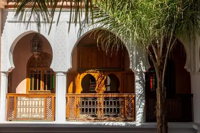 a building with two arches and a palm tree at Riad Agdal Royal & Spa in Marrakech