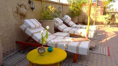 a group of white lounge chairs and a table at Riad Agdal Royal & Spa in Marrakech