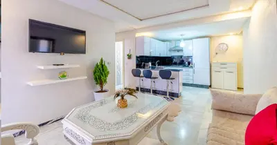 a living room with a table and a kitchen at AiM HOUSE in Marrakech