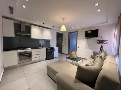 a living room with a couch and a kitchen at AiM HOUSE in Marrakech