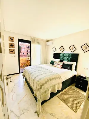 a bedroom with a large bed with a green headboard at AiM HOUSE in Marrakech