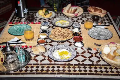 a table with plates of food on a checkered table cloth at Héritage Lalla Aicha Hotel & Spa in Marrakech
