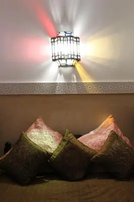 a light hanging over a couch with pillows at Riad la medersa in Marrakech