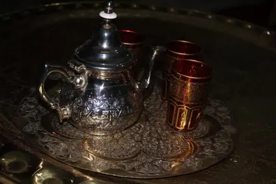 a silver tea kettle and two red cups on a tray at Riad la medersa in Marrakech