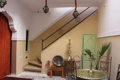 a room with a staircase with a table and a stair case at Riad la medersa in Marrakech