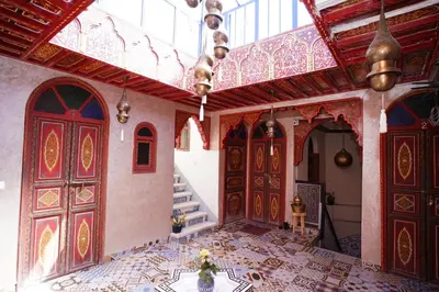 a room with red doors and a tile floor at Riad Dar Essassi 23 in Marrakech