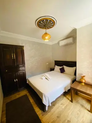 a bedroom with a white bed and a chandelier at Riad Dar Essassi 23 in Marrakech