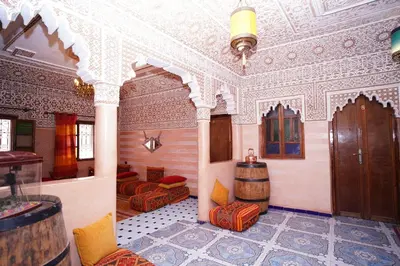 a room with two beds and a barrel in it at Riad Dar Essassi 23 in Marrakech