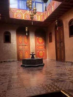 an empty room with red and yellow doors and a statue at Riad Dar Essassi 23 in Marrakech