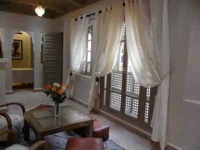 a living room with a table and a window at Riad et Spa Misria Les Oliviers in Marrakech