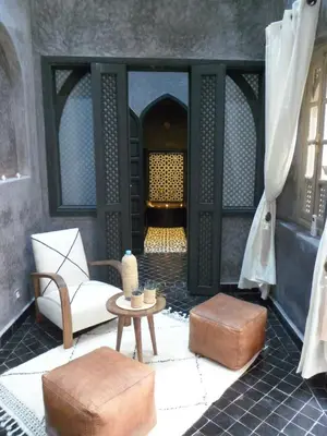a living room with a chair and a table at Riad et Spa Misria Les Oliviers in Marrakech