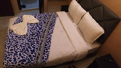 a bed with a blue and white blanket and a pillow at Riad Rayan's Guests in Marrakech