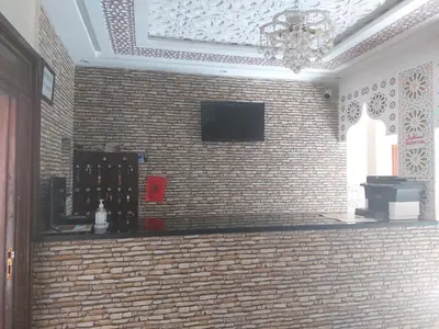 a room with a brick wall with a television on it at Riad Rayan's Guests in Marrakech