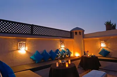 a patio with two tables with blue pillows at Riad Papillon by Marrakech Riad in Marrakech