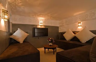 a living room with a couch and a tv at Riad Cinnamon by Marrakech Riad in Marrakech
