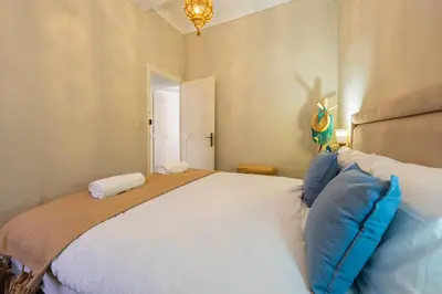 a bedroom with a large white bed with blue pillows at Dar Noubti in Marrakech