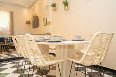 a white dining room table with wicker chairs at Résidence alqaria assiyahiya full private riad in Marrakech