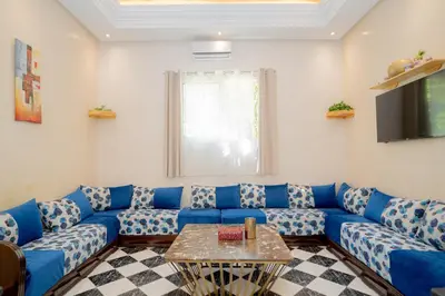 a living room with a blue couch and a table at Résidence alqaria assiyahiya full private riad in Marrakech