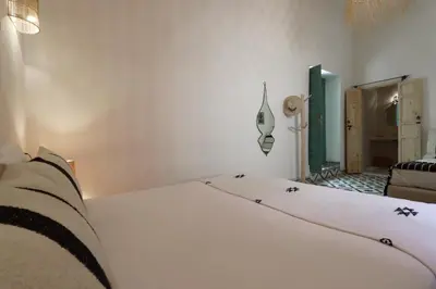 a bedroom with a white bed with black stars on it at Riad NaaNaa Bed & Breakfast in Marrakech